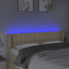 sengegavl med LED-lys 147x16x78/88 cm stof cremefarvet